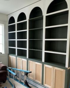 an empty room with some shelves being painted