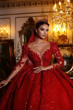 a woman wearing a red gown and tiara in a room with chandeliers