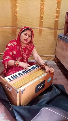 a woman sitting on the floor playing an instrument