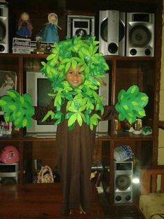 a child in a costume made to look like a tree with green leaves on it