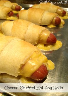 hotdogs wrapped in cheese and sitting on top of a baking sheet with the words cheesy stuffed hot dog rolls