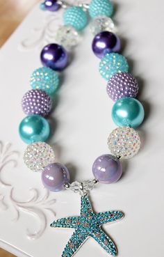 "This necklace features a beautiful rhinestone starfish pendant. Part of my \"Summer Nautical\" line, with a summery palette of aqua blue, purple and iridescent sparkle inspired by a mermaid at sea, it is the perfect accent for your photo shoot or outfit. To see more summer themed necklaces visit my summer section: https://www.etsy.com/shop/ChunkyStuffByLBB?section_id=17113232&ref=shopsection_leftnav_4 ✔ Necklaces come in child to adult sizes with a 2\" extender chain and jumbo lobster clasp Summer Necklaces, Pen Ideas, Purple Beads, Starfish Pendant, Starfish Necklace, Bubblegum Beads, Chunky Jewelry, Chunky Beads, Summer Necklace