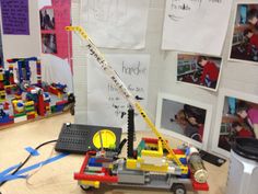 there is a toy truck made out of legos on the table in front of some pictures