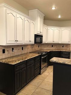 a kitchen with white cabinets and granite counter tops