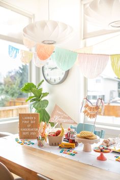 a wooden table topped with lots of food next to a clock and potted plant