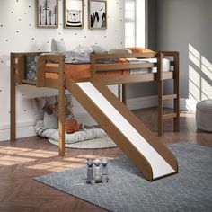 a child's bed with a slide in front of it and pictures on the wall