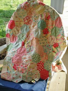 a patchwork quilt sitting on top of a wooden chair