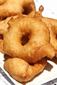 some fried doughnuts are on a white plate