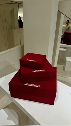 three red boxes sitting on top of a white table