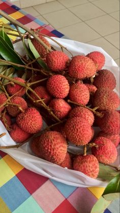 a bunch of fruit sitting on top of a table next to a leafy plant