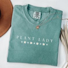 Wonderful design for women who loves Plant Lady letter design shirt.Grab this design as a gift for your girlfriend,sister,mother or who loves Plant Mom shirt.Or make yourself happy to have this cute design t-shirt :) A Plant Lady shirt is a type of t-shirt that features a design inspired by the Plant Lover Gift.Plant Lady shirts are popular among Plant Mom letter t-shirt lovers and make a great gift for any Plant Lady enthusiast. 🌿 Made from premium quality, soft cotton fabric, this shirt ensur Green Tops With Letter Print For Gardening, Cotton Tops With Plant Print As Gift, Cotton Tops With Plants Print For Gift, Cotton Tops With Plant Print For Gifts, Cotton Tops With Plant Print, Green Relaxed Fit T-shirt For Gardening, Crew Neck Cotton Shirt For Gardening, Green Graphic Print T-shirt For Gardening, Cotton T-shirt With Letter Print For Gardening