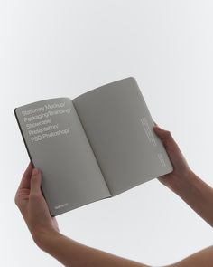 a person holding an open book in their hands with the cover opened to show text