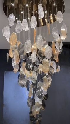 a chandelier made out of many different types of glass discs hanging from the ceiling