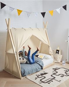 a person laying on top of a bed with a tent in the middle of it