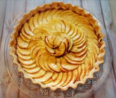 an apple pie is sitting on a glass plate