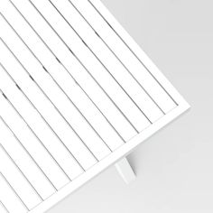 the top of a white table with vertical slats on one side and two straight lines on the other