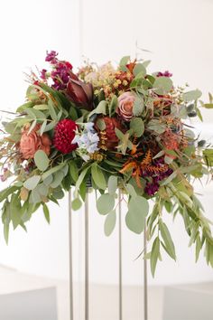 an arrangement of flowers and greenery in a vase