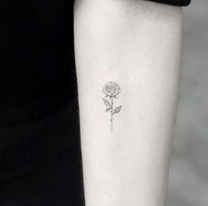 a single rose tattoo on the left inner arm