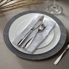 a white plate topped with silverware next to a fork and knife on top of a table