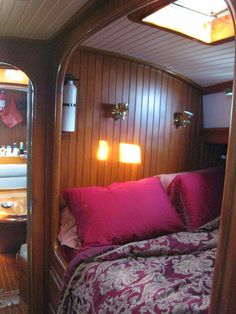 a bed sitting inside of a bedroom on top of a wooden floor next to a mirror