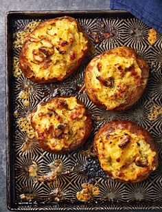 baked potatoes with cheese and herbs on a metal tray