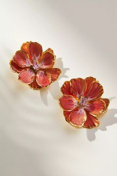 two red flower shaped brooches sitting on top of a white table next to each other