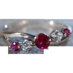 I am offering you this gorgeous vintage 10 k white gold (stamped) ring with 5 total gorgeous round shaped, genuine ruby and white topaz stones, all prong set in a fabulous curved wedding band style. This band ring is spectacular featuring fabulous brilliantly cut genuine stones. These stones span across the entire top surface of this band style ring, you will be noticed when wearing this ring. These stones have color saturation and intensity that is endless, as seen in the provided pictures. The Diamond White Ruby Ring For Anniversary, Anniversary Ruby Ring In Diamond White, Anniversary Diamond White Ruby Ring, White Ruby Ring With Center Stone For Anniversary, Classic White Ruby Promise Ring, Vintage White Ruby Ring For Anniversary, White Band Ruby Ring Promise Ring, Dazzling Ruby Ring With Cubic Zirconia For Promise, White Ruby Ring For Promise, Round Cut