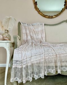 a bed with a white bedspread sitting next to a mirror on the wall