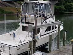 a white boat is docked at the dock