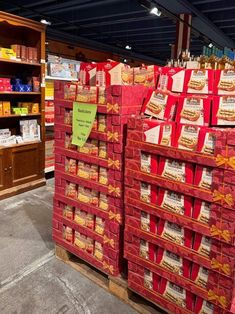 several red boxes stacked on top of each other in front of shelves filled with food