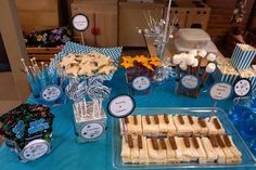 a blue table topped with desserts and candies