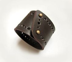 Handmade dark brown bracelet, made of heavy leather with hole pattern. It has  brass color snap closure.Main color: dark brownMaterial:Heavy leatherClosure: brass color snapsMeasurement: Wide- 4.8 cm (1.9 inch) SizeS- fits wrist with  circumference: 14 - 15.5 cm; 5.5 - 6.1 inchM- fits wrist with  circumference: 16 - 17.5 cm; 6.2 - 6.9 inchL- fits wrist with  circumference: 18 - 19.5 cm; 7 - 7.7 inchXL - fits wrist with  circumference: 20 - 21.5  cm; 7.9 - 8.5 inchThe length of bracelet can be re Leather Sketchbook, Mens Cuff, Brown Bracelet, Leather Wristbands, Women Bracelet, Dark Brown Color, Leather Cuffs, Brass Color, Leather Jewelry