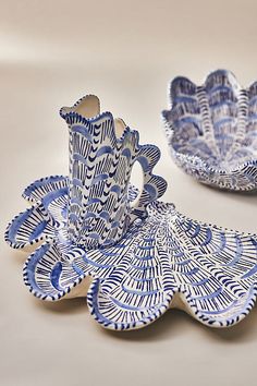 two blue and white dishes sitting on top of a table next to each other,