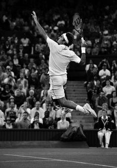 a man jumping in the air while holding a tennis racquet