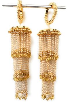 two pairs of gold toned earrings hanging from a metal rod on a white background with clippings