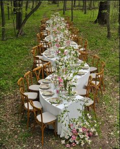 a long table is set with flowers and plates