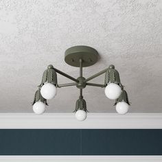 a ceiling light with five white balls hanging from it's center and two green lights on each side