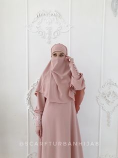 A beautiful and elegant pale pink dress and khimar with lace and decorative buttons. This gorgeous white gown has high cuffs, decorated with handmade lace and beautiful buttins, and comes with an elegant khimar. The khimar is decorated with the same kind of handmade lace and creates a tender silhouette. This dress is a soft, free-flowing shape, that doesn't cling to the figure and helps hide any imperfections, while underlining the advantages. A perfect fir for fashion conscious modest ladies. D Traditional Pink Abaya For Wedding, Modest Pink Hijab For Eid, Long Sleeve Pink Abaya For Wedding, Traditional Pink Wedding Abaya, Long Sleeve Pink Khimar For Eid, Modest Wedding Niqab For Eid, Pink Niqab For Eid, Modest Style Khimar For Wedding And Eid, Modest Long Sleeve Khimar For Wedding