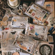 there are many different papers on the table with a cup and saucer next to it