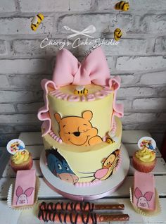 a winnie the pooh birthday cake and cupcakes