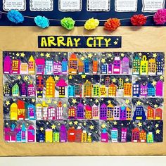 a bulletin board is decorated with colorful paper cityscapes and flowers on a string