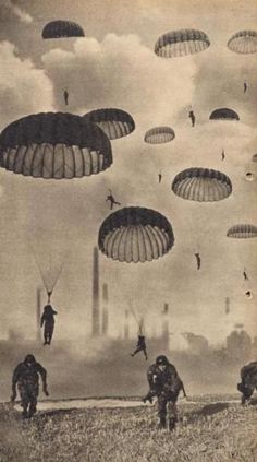 an old black and white photo of people parachuting in the sky with parachutes