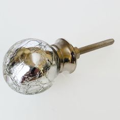 a close up of a metal door knob on a white surface with a screw in the middle