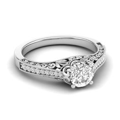 a white gold engagement ring with an intricate filigree design on the band and side stones