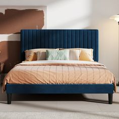 a bed with blue headboard and pillows in a room that has been painted brown