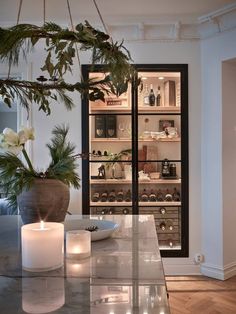 a glass table with candles on it in front of an open refrigerator