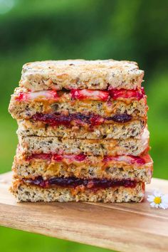 three sandwiches stacked on top of each other with strawberries in the middle and oatmeal toppings