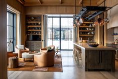 a living room filled with furniture next to a kitchen and an open door leading to a patio