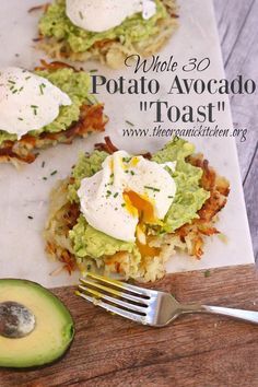 an avocado toast with eggs on it and a fork sitting next to it