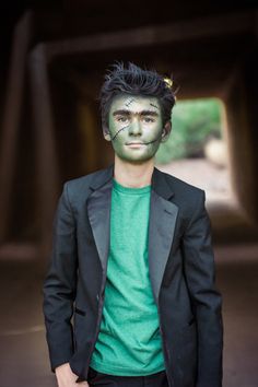 a man with black hair and green face paint